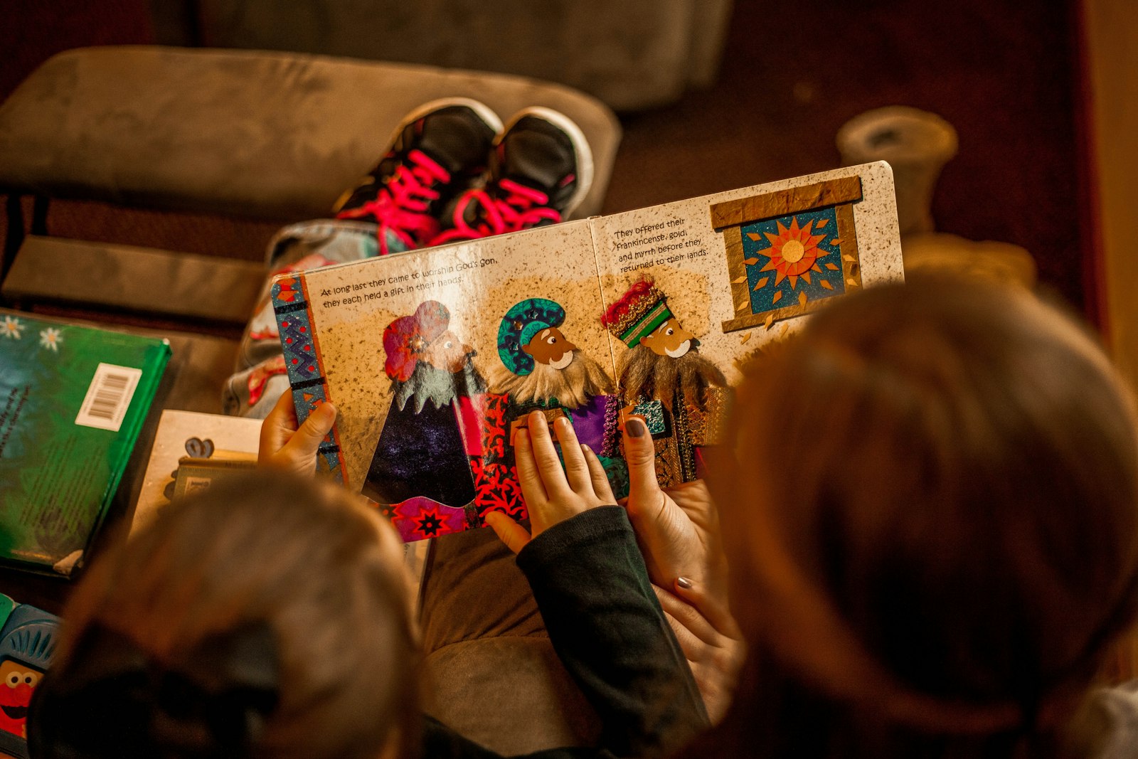 Two young children sitting together reading a book.